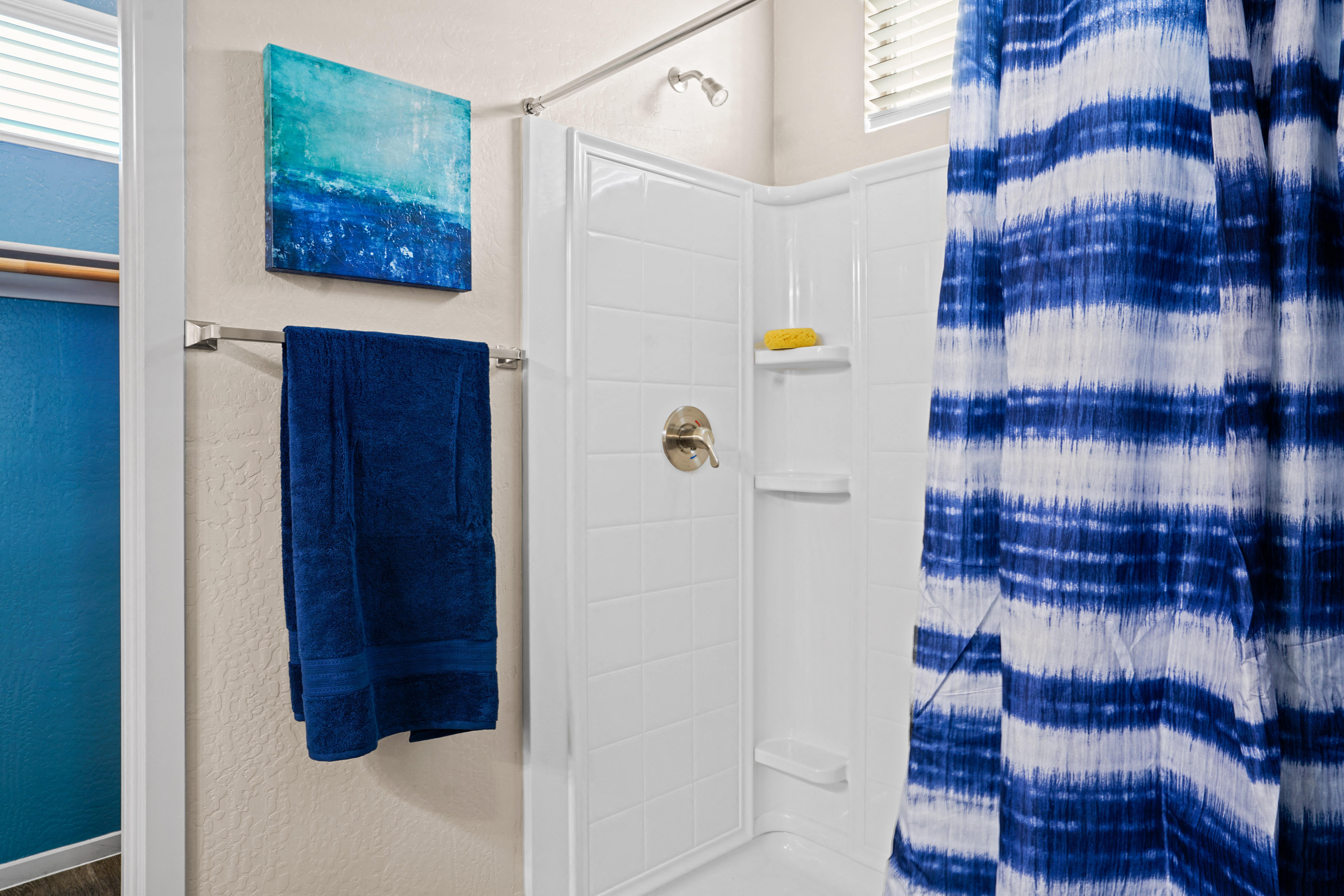 a small bathroom with a shower and blue towels at Olive Queen Creek Apartments, Queen Creek, AZ, 85142